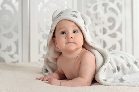 Portrait of cute little baby boy on bedの写真素材