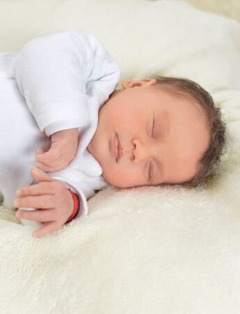 Portrait of cute little baby boy on bed sleepingの写真素材