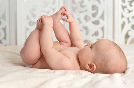 Portrait of cute little baby boy on bedの写真素材