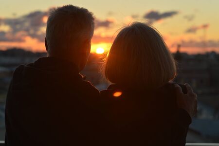 Happy elderly couple at tropical beach at sunsetの写真素材