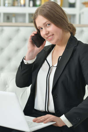 Teen girl in formal wear talking on phoneの写真素材