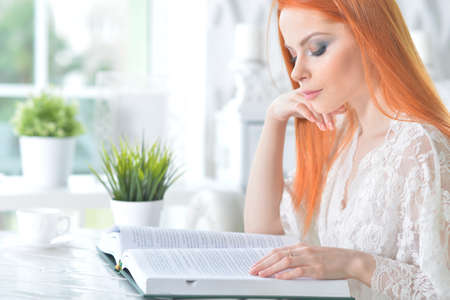 Young attractive woman with book in the morning