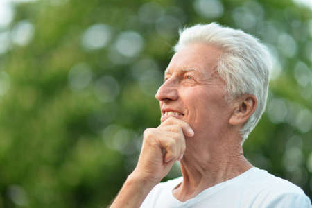 Close up portrait of smiling senior man in park