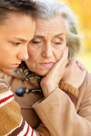 Close up portrait of grandmother and grandson hugging in parkの写真素材