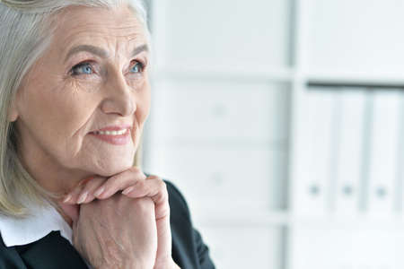 Close-up portrait of emotional old businesswoman in officeの写真素材