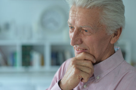 Portrait of thoughtful senior man at homeの写真素材