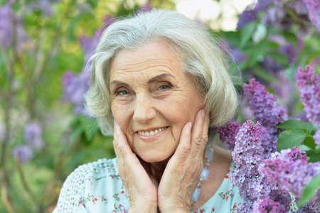 Happy senior beautiful woman on lilacs background