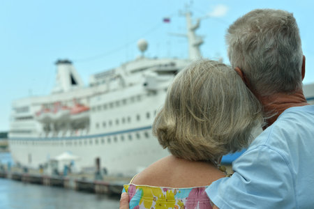 Portrait of senior couple sitting by shipの写真素材