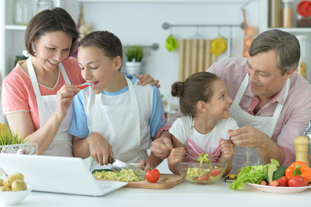 Portrait of happy family cooking together in kitchenの写真素材