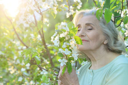 Happy senior beautiful woman in spring parkの写真素材