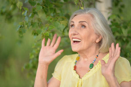 Smiling senior woman in park in summer