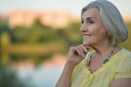 Smiling senior woman in park in summerの写真素材
