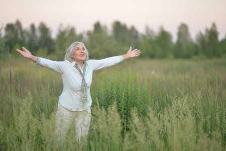 Smiling senior woman in park in summerの写真素材
