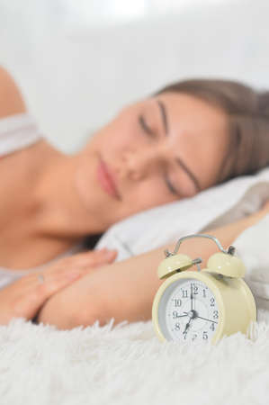 Beautiful young woman sleeping on soft bed on morning