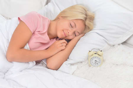 Cute girl sleeping in bed at homeの写真素材