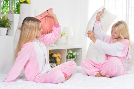 Portrait of cute girls posing on bedの写真素材