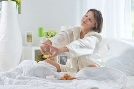 Beautiful young woman awaking on soft bed on morningの写真素材