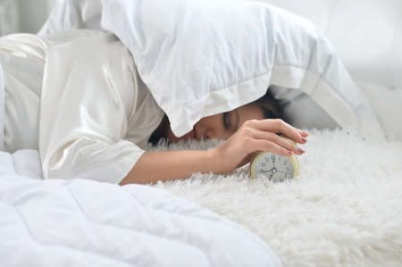 Beautiful young woman sleeping on soft bed on morningの写真素材
