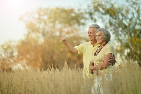 Happy senior couple running in autumn parkの写真素材