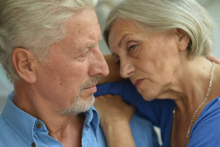 Portrait of sad senior couple posing at home
