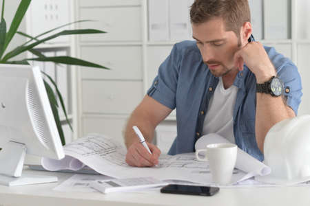Portrait of handsome young man working in officeの写真素材
