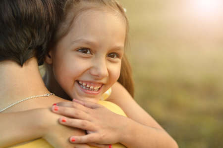 Portrait of happy mother and daughter hugging outdoorsの写真素材