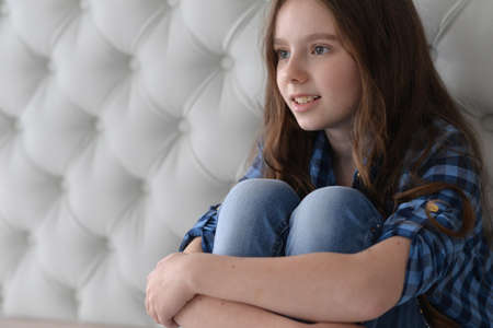 Portrait of cute girl sitting on the floorの写真素材