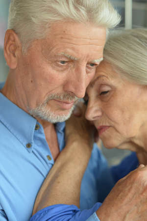 Portrait of sad senior couple posing at home