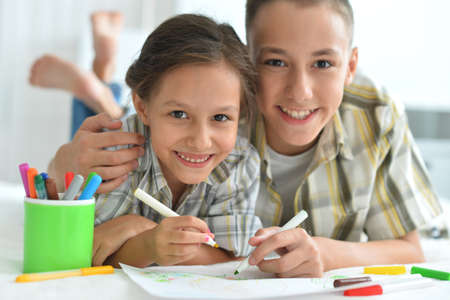 Porait of smiling brother and sister drawing togetherの写真素材