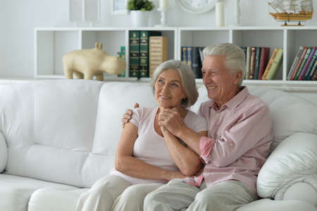 Senior couple sitting on sofa at homeの写真素材