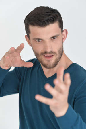 Handsome young man showing something in studio