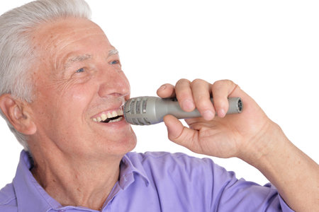 Portrait of senior mansinging with microphone isolated on white backgroundの写真素材