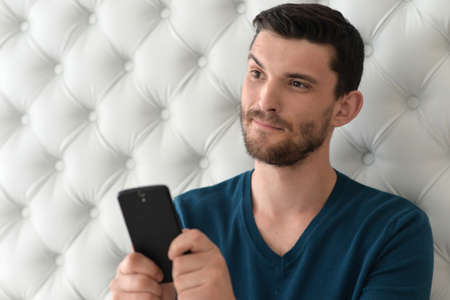 Portrait of handsome young man posing using smartphone