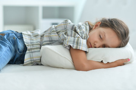 Porait of cute little girl sleeping in bed at homeの写真素材