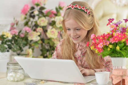 Beautiful girl with laptop in the kitchen