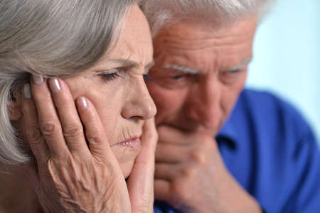 Portrait of sad senior couple posing at homeの写真素材
