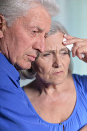 Portrait of sad senior couple posing at homeの写真素材