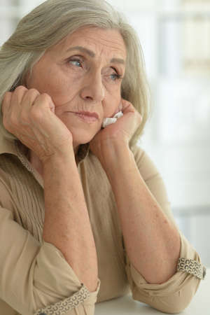 Portrait of sad senior woman with headacheの写真素材