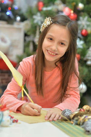 Happy girl writing letter to Santa Clausの写真素材