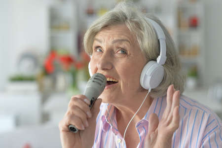 Portrait of senior woman in headphones with microphoneの写真素材