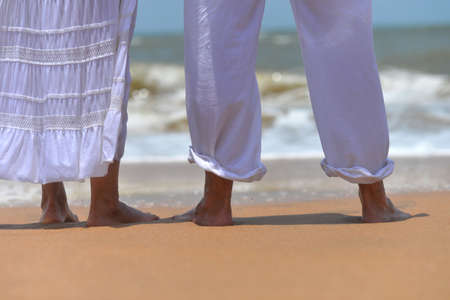 Happy elderly couple walking on tropical beach