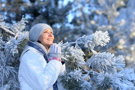 Happy young woman posing in snowy winter parkの写真素材