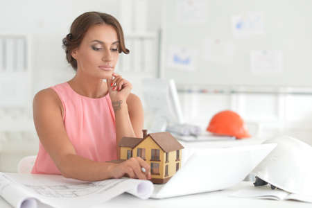 Beautiful female architect with laptop in modern officeの写真素材