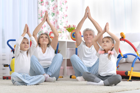 Grandfather and grandmother together with their granddaughters are trainingの写真素材