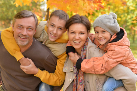 Young family with little kids in autumn park on sunny day.の写真素材