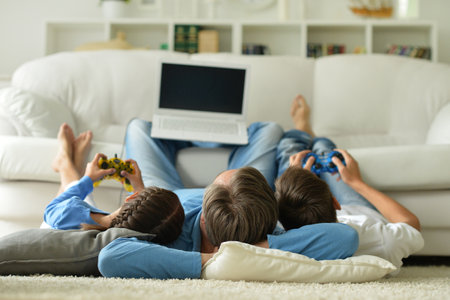 parents with children with laptops are lying on the backの写真素材