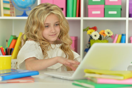 girl using laptop at desk at homeの写真素材