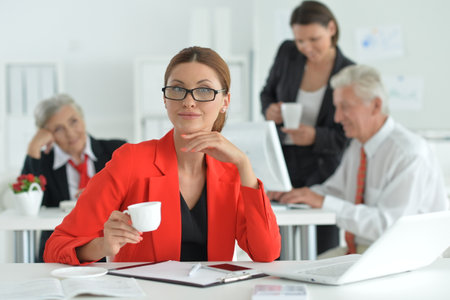 Portrait of a young woman with a laptop in officeの写真素材
