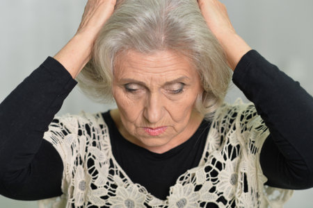 Portrait of sad senior woman with headacheの写真素材