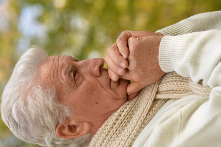 Portrait of an old man having a headacheの写真素材
